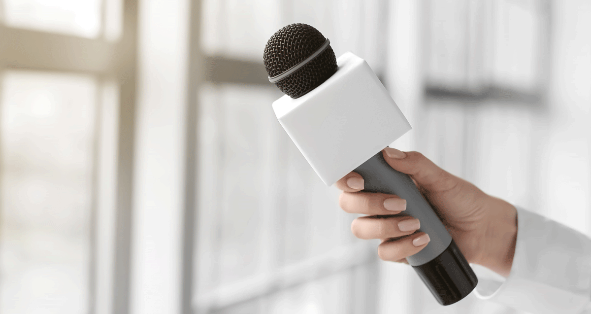 Interview-Situation mit Mikrofon einer ehemalige Auszubildenden